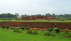 Visitors walking among the brick remains of Shalban Vihara